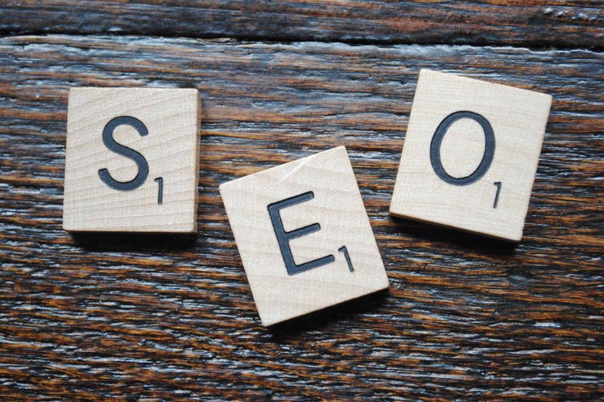 Lettres formant le mot SEO disposées sur une table en bois