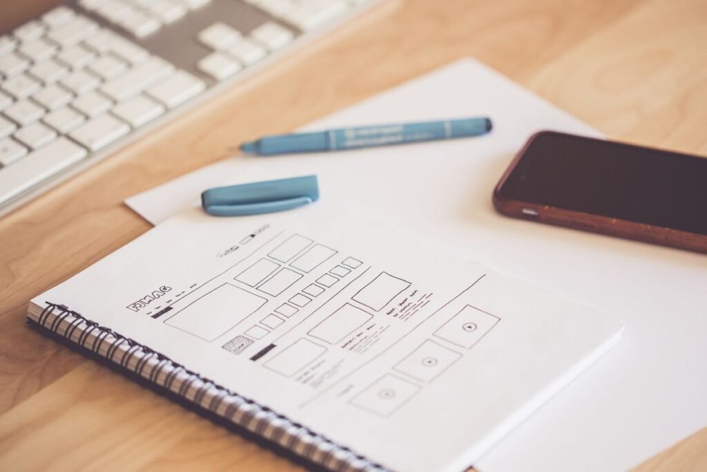 Croquis de maquette de site web, smartphone et clavier sur un bureau
