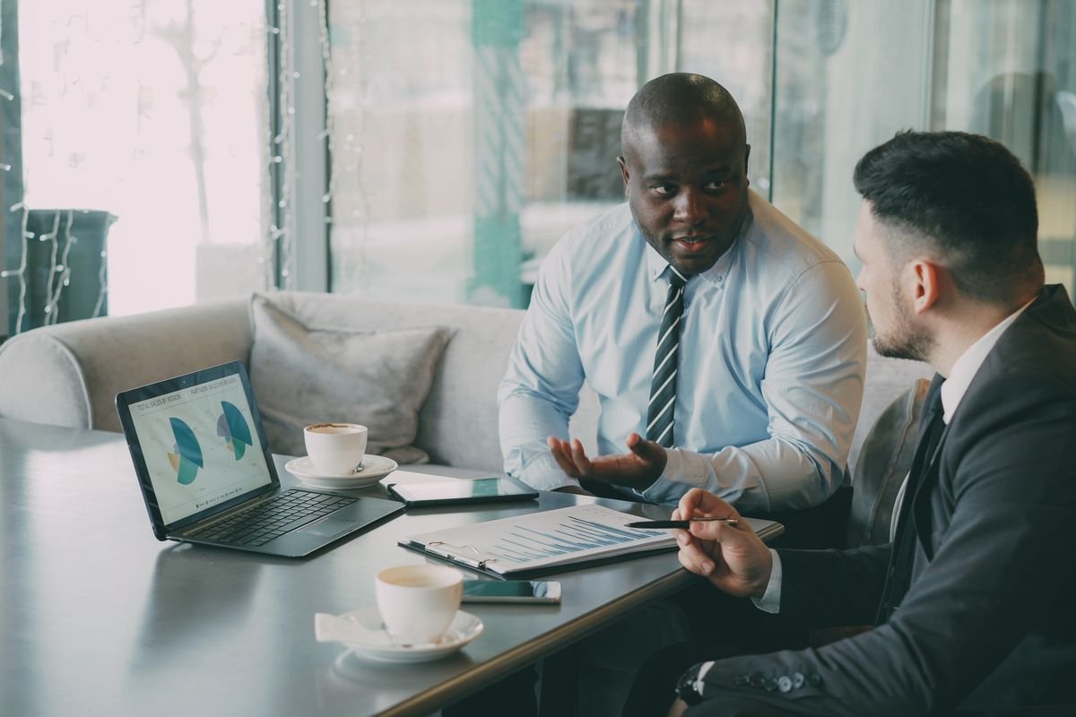 Deux professionnels analysant des documents et un ordinateur portable