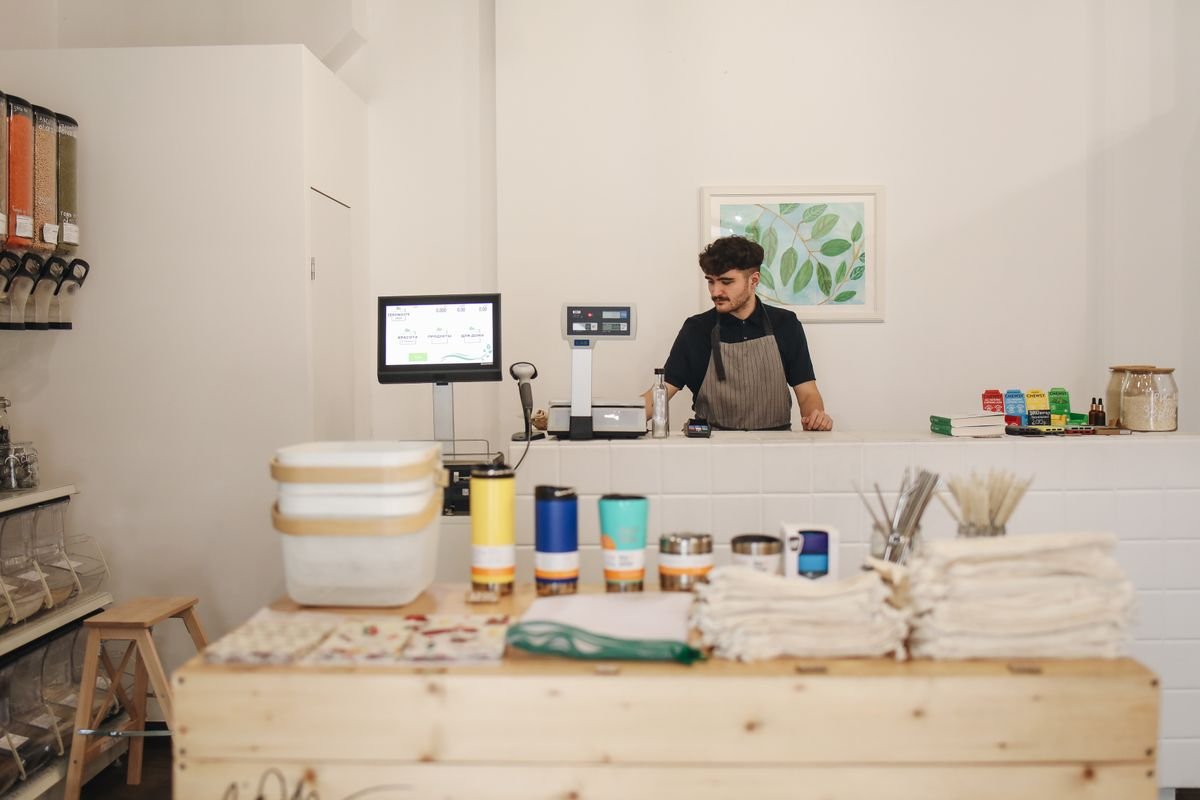 Commerçant derrière le comptoir de sa boutique de vrac