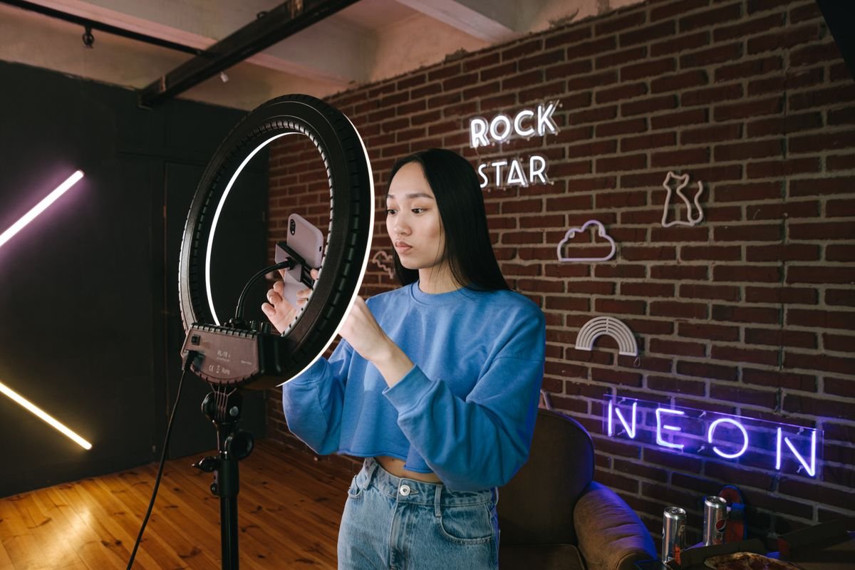 Influenceuse installant son éclairage pour tourner une vidéo