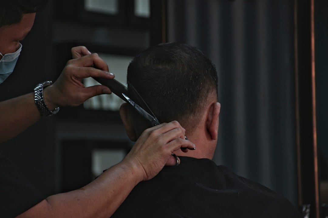 Coiffeur réalisant une coupe sur un client en salon
