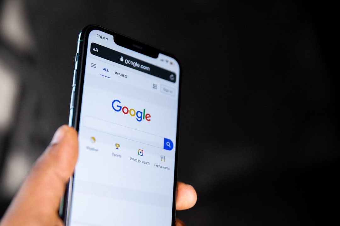 Page d'accueil de recherche Google affichée sur un smartphone tenu à la main