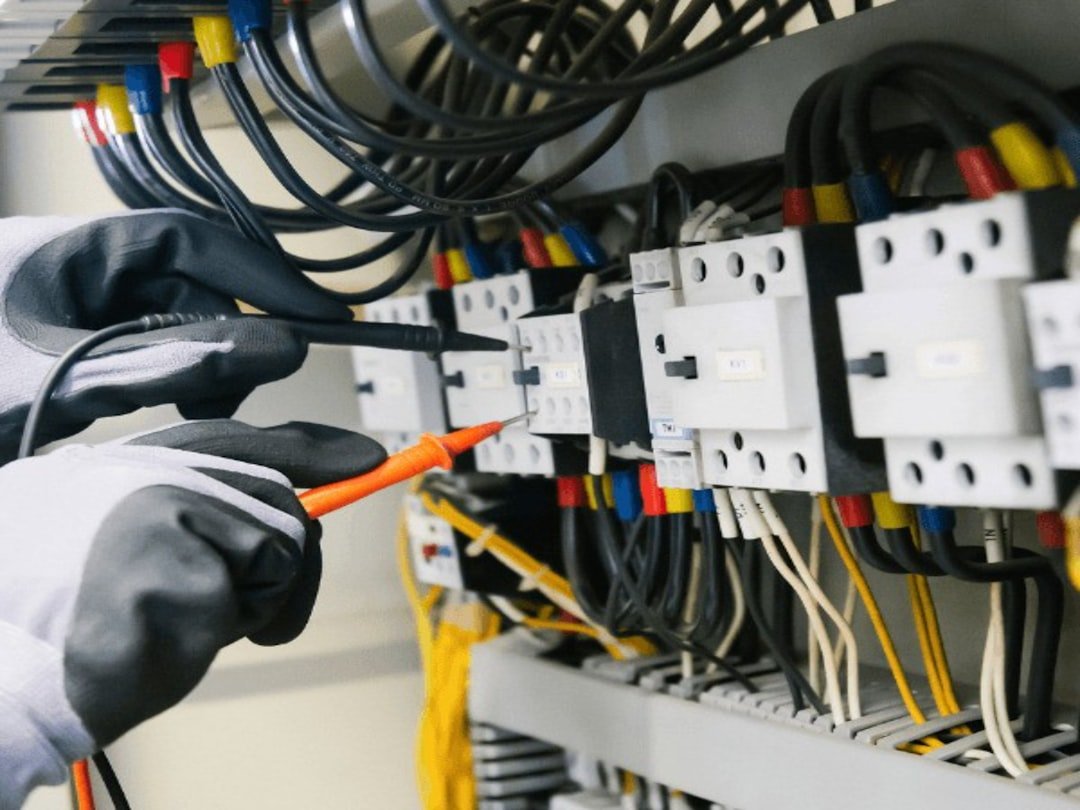 Électricien testant un tableau électrique au multimètre lors d'une intervention