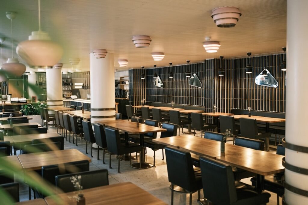 Salle de restaurant dressée avec tables et chaises avant le service
