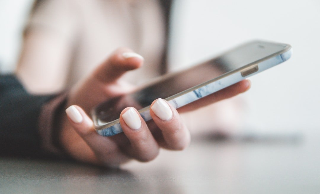 Main tenant un smartphone affichant une recherche