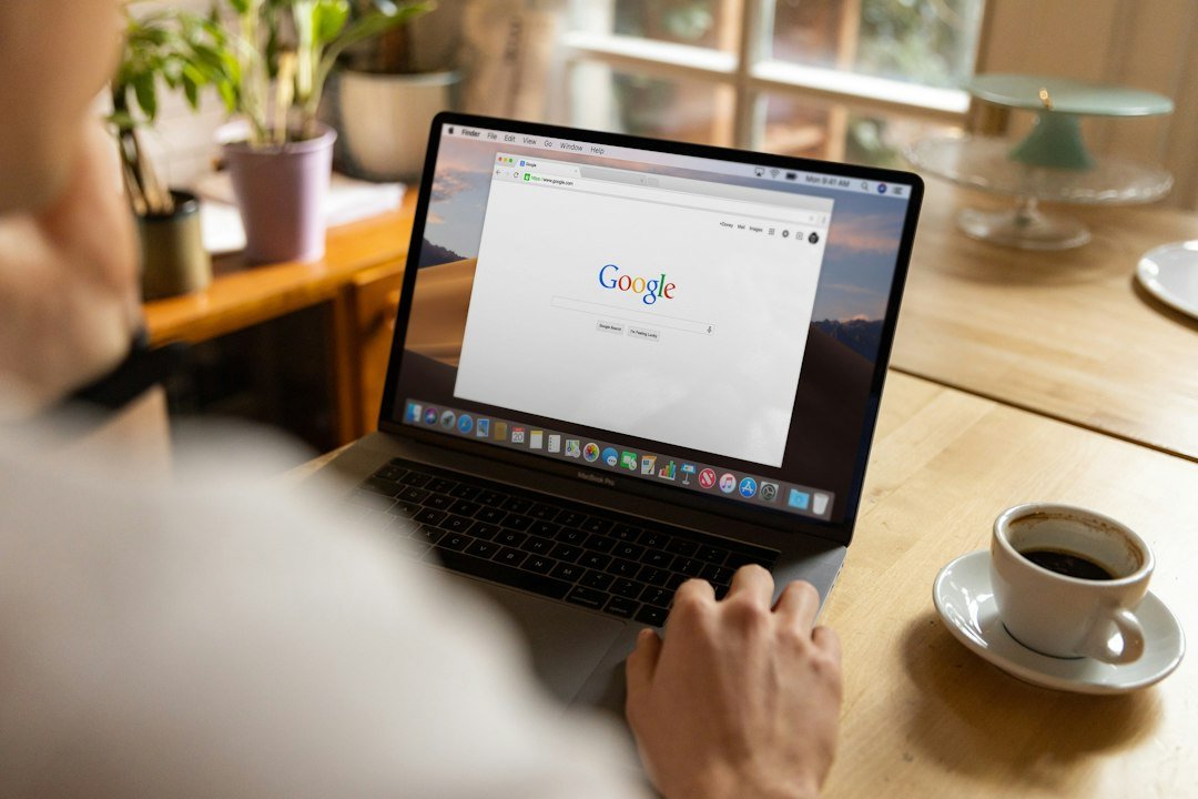 Homme effectuant une recherche Google sur un ordinateur portable dans un café