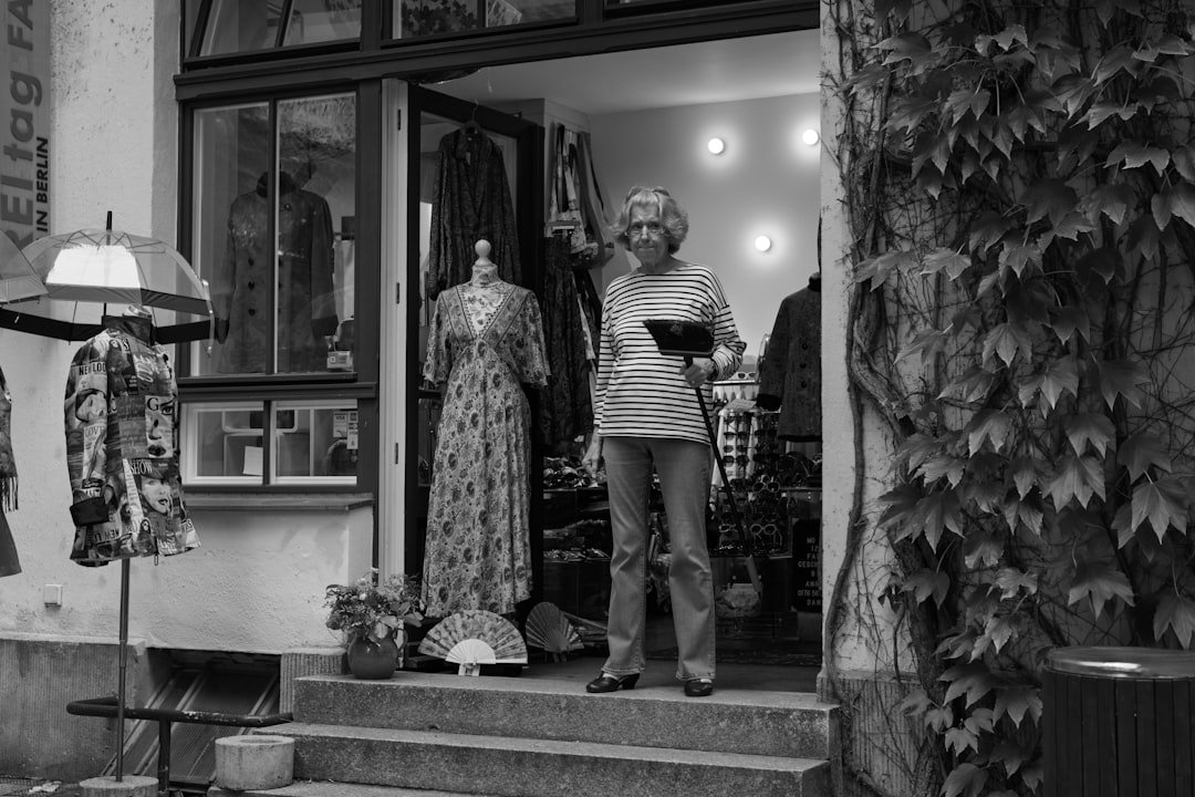 Une commerçante devant l’entrée de sa boutique de vêtements vintage